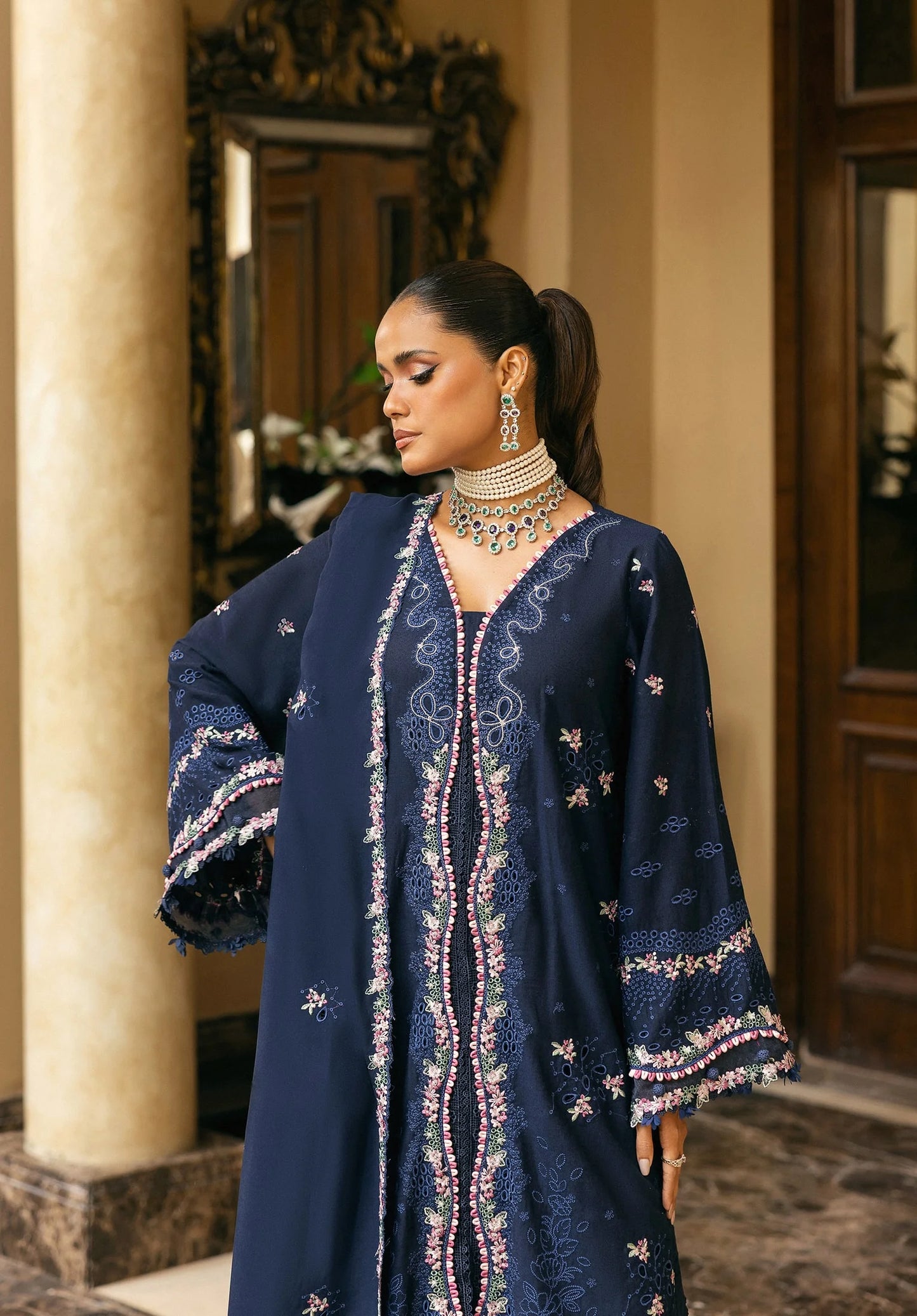 Woman wearing a navy blue embroidered outfit with jewelry in an elegant indoor setting in ELAF LUXURY WINTER.