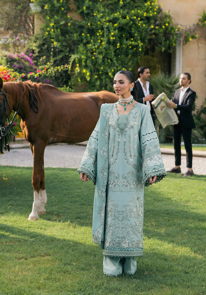 Woman in a light blue traditional outfit standing on grass with a horse in the background from elaf LUXURY WINTER '25
