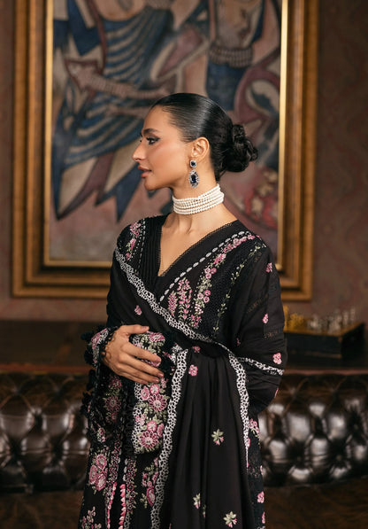 Woman wearing a black embroidered dress with floral patterns in a room with a painting on the wall in ELAF LUXURY WINTER